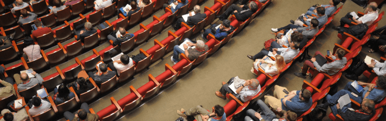 Teilnehmer eines Kongresses hören einem Vortrag zu.