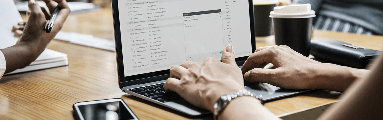 Person im Meeting schreibt am Laptop